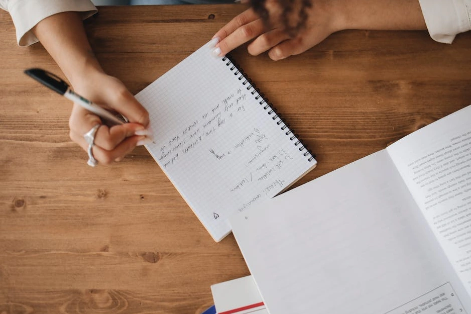 Osoba píšící si poznámky do zápisníku